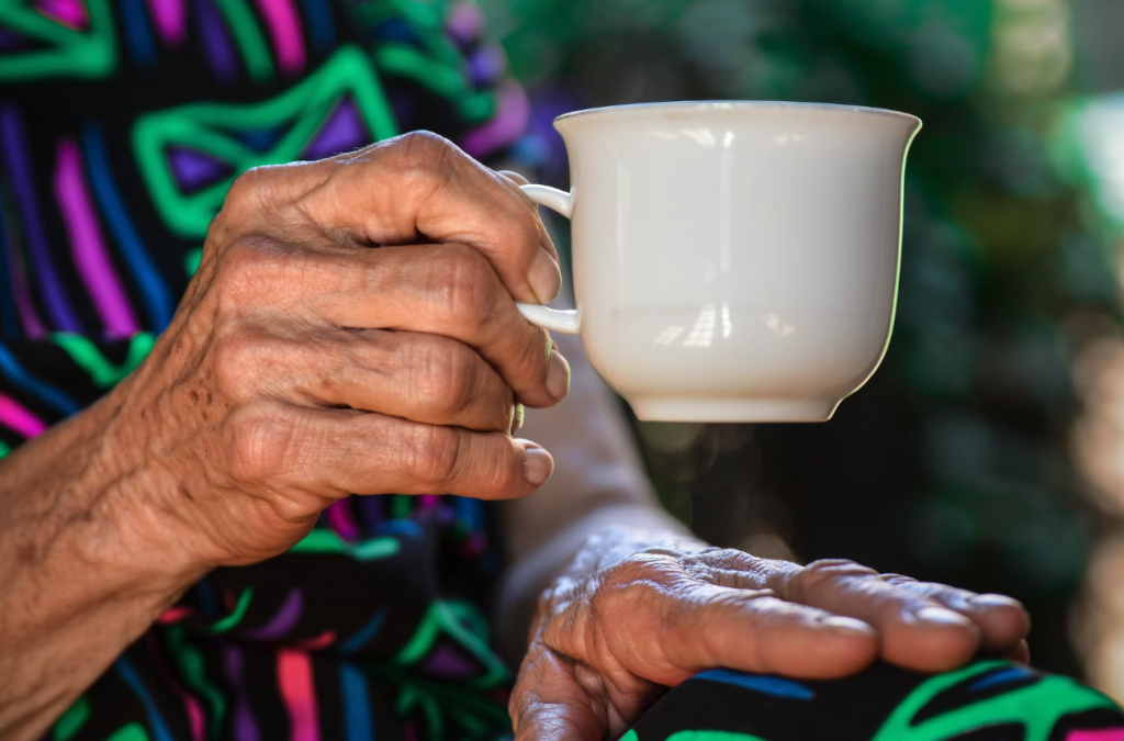 elderly woman drinking cup of tea in care home uk